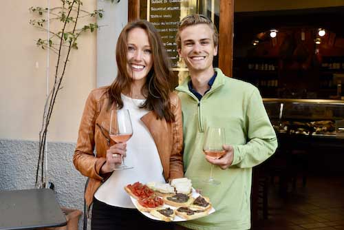 Castagneto Food Tours Guest in front of restaurant with local Tuscany food and red wine